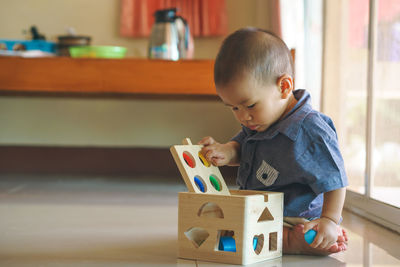 Cute boy playing with toys at home