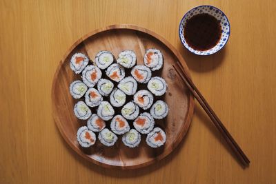 Directly above shot of sushi served in plate with soy sauce on table