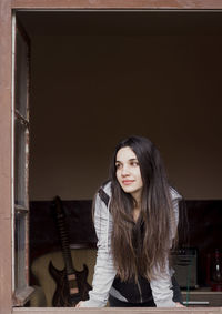 Portrait of young woman sitting on wall