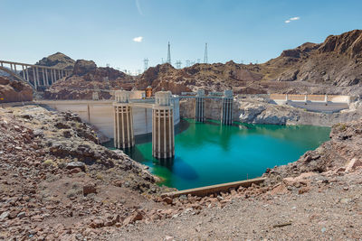 Panoramic view of dam on riverbank against sky