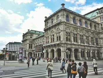 Buildings in city against cloudy sky