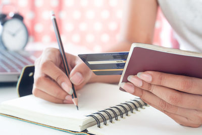 Close-up of woman reading book on table