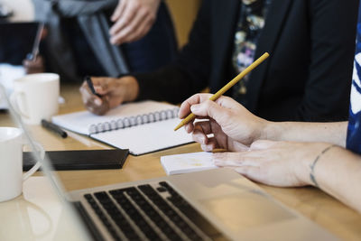 Businesswoman writing during meeting at office