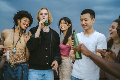 Multiracial young friends enjoying party at dusk