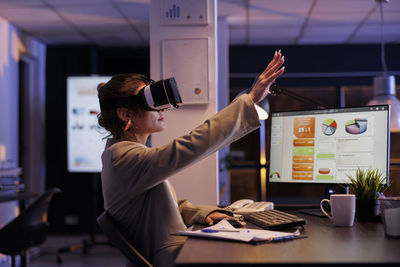 Side view of businessman using laptop at office