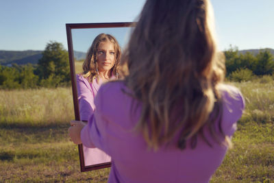 Woman standing on field against sky