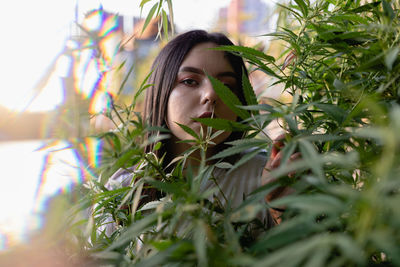 Portrait of young woman amidst plants