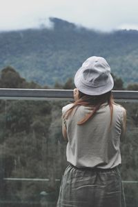 Rear view of woman standing against mountains