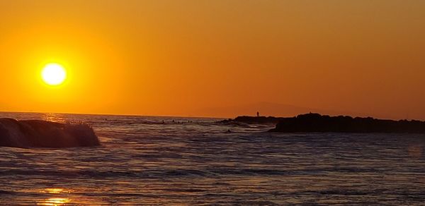 Scenic view of sea against orange sky