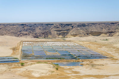 Scenic view of desert landscape with salt mining against sky, mucuio, angola