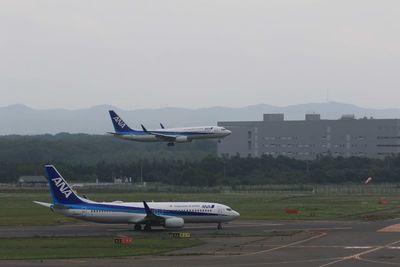 Side view of airplane on airport runway against sky