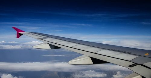 Cropped image of airplane flying over clouds