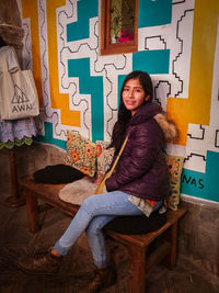 Portrait of young woman sitting on chair