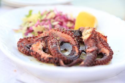 Close-up of grilled octopus on plate with vegetables 