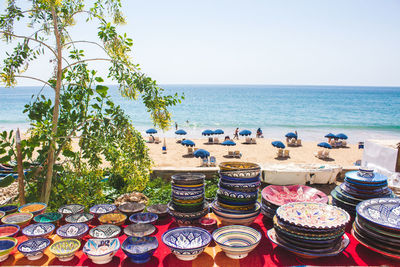 Various food on table by sea against clear sky