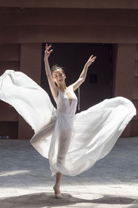 Full length of ballet dancer dancing outdoors