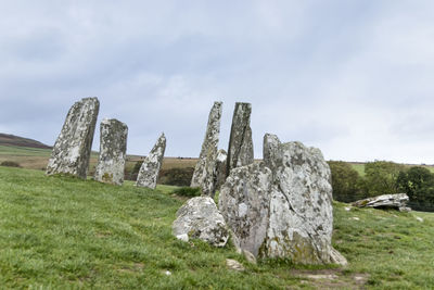 Rocks on field against sky