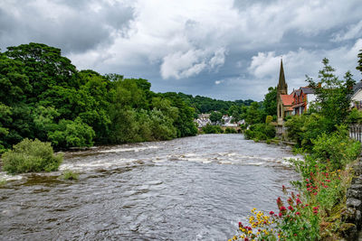 River dee by llangollen methodist church against cloudy sky