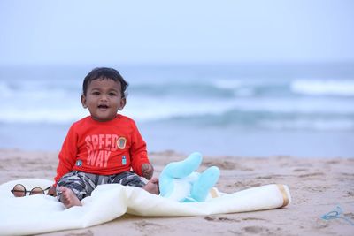 Portrait of cute boy sitting on beach