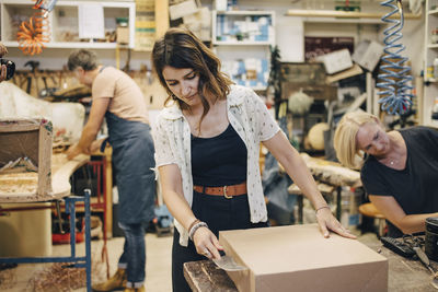 Female and male upholstery workers working in workshop