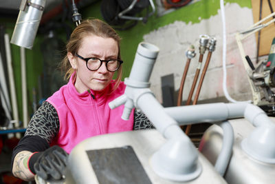 Female plumber working in workshop