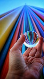 Close-up of person holding multi colored umbrella