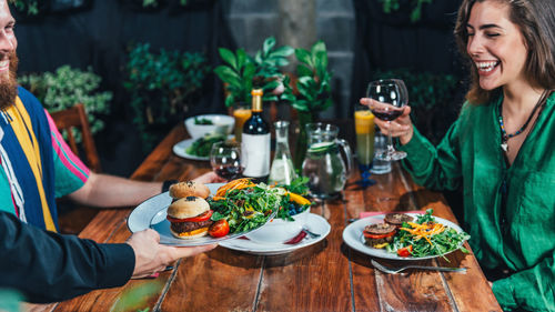 Midsection of woman holding food on table at restaurant