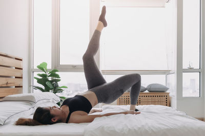 Young woman lying on bed at home