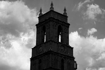 Low angle view of clock tower against cloudy sky