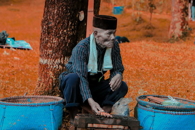 Side view of senior man preparing food on field