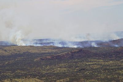 Smoke emitting from bush fires against sky