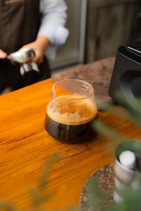 Midsection of man holding coffee on table