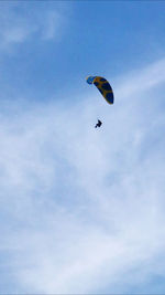 Low angle view of person paragliding against sky