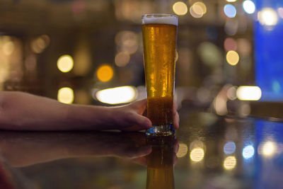 Close-up of hand holding beer glass