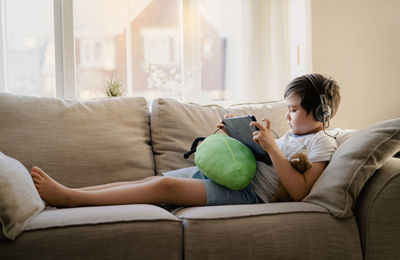 Rear view of woman sitting on sofa at home