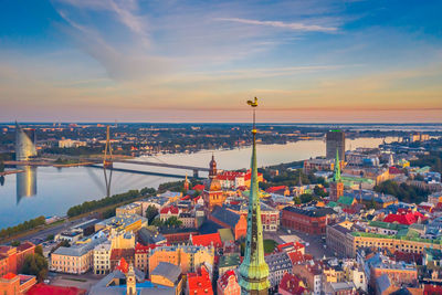 High angle view of city at river during sunset