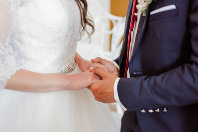 Midsection of couple holding hands