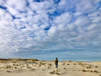 Rear view of man standing on land against sky