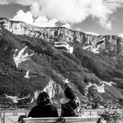 Rear view of people flying over mountains