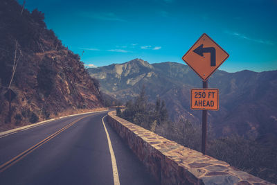 Road sign against mountain range