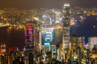 Illuminated buildings at victoria harbour in city during night
