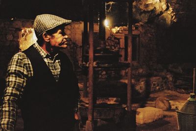 Man standing by fire at night