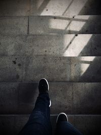 Low section of man standing on tiled floor