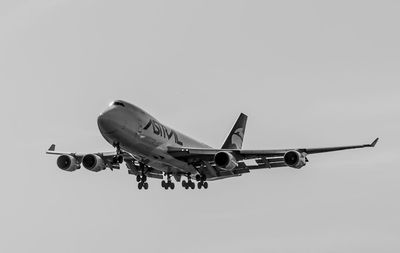 Low angle view of airplane flying against clear sky