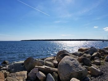 Rocks by sea against sky