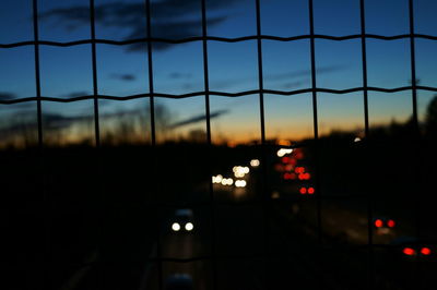 Illuminated road against sky at night