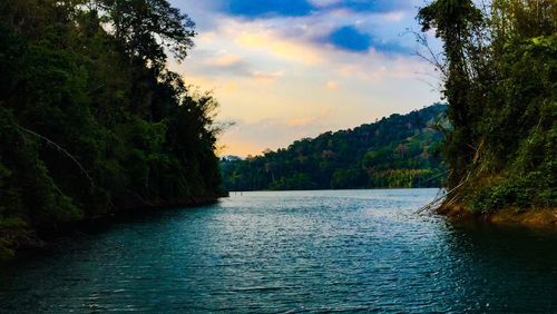 Scenic view of river and mountains against sky