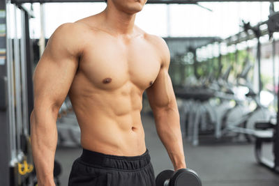 Shirtless man exercising at gym