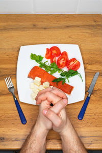 Cropped hand of woman holding food on table