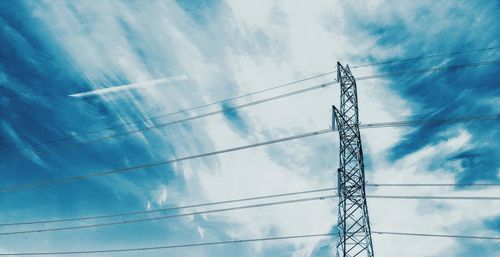 Low angle view of electricity pylon against blue sky